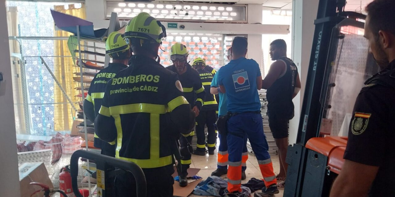 Los bomberos rescatan a una persona atrapada en una máquina elevadora en un local de la avenida de Sanlúcar